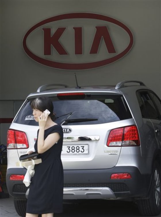 A South Korean woman walks by a service center of Kia Motors in Seoul, South Korea, Tuesday. The top executive at Kia Motors has resigned after the company issued a global recall for 100,000 vehicles over defective wiring.